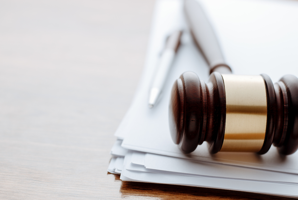 Image of a gavel and legal documents on a desk.