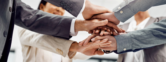 Image of a group of people joining hands in solidarity.