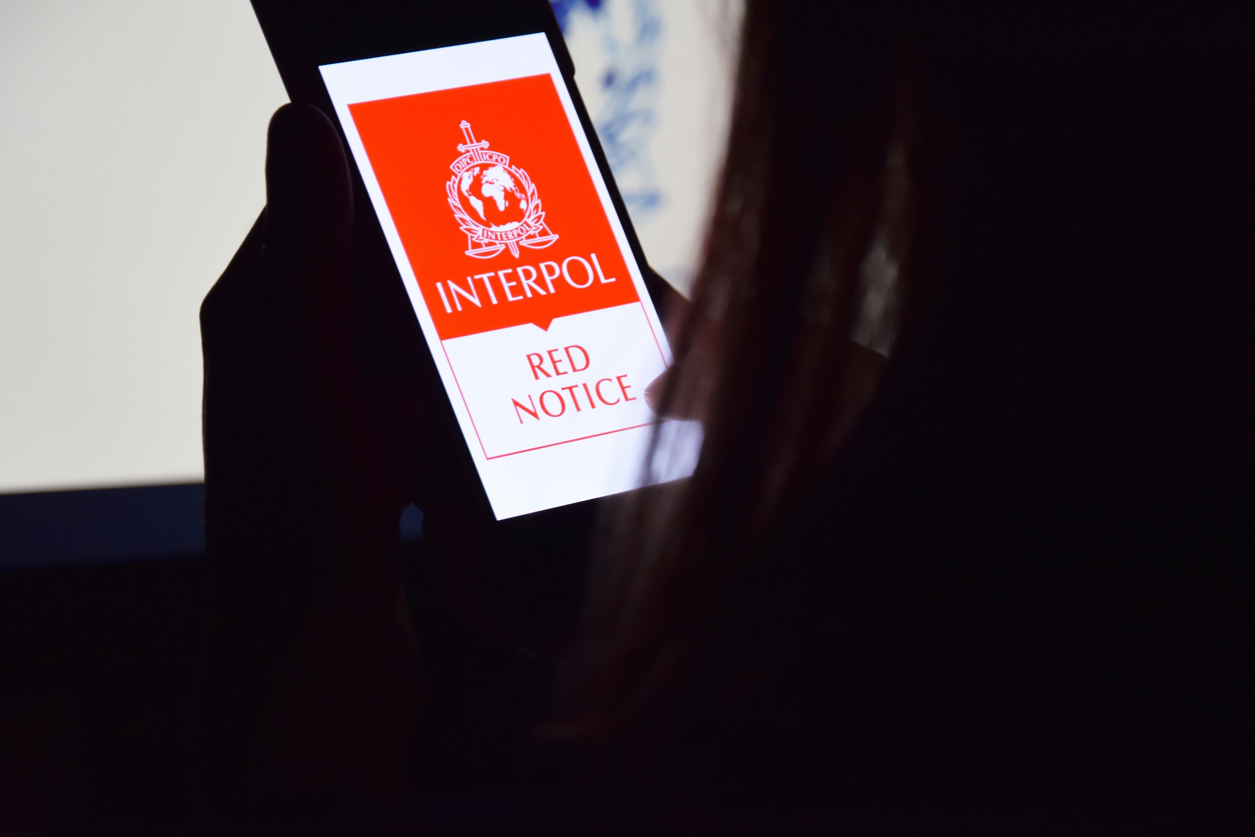 Image of a tablet displaying the words INTERPOL Red Notice.