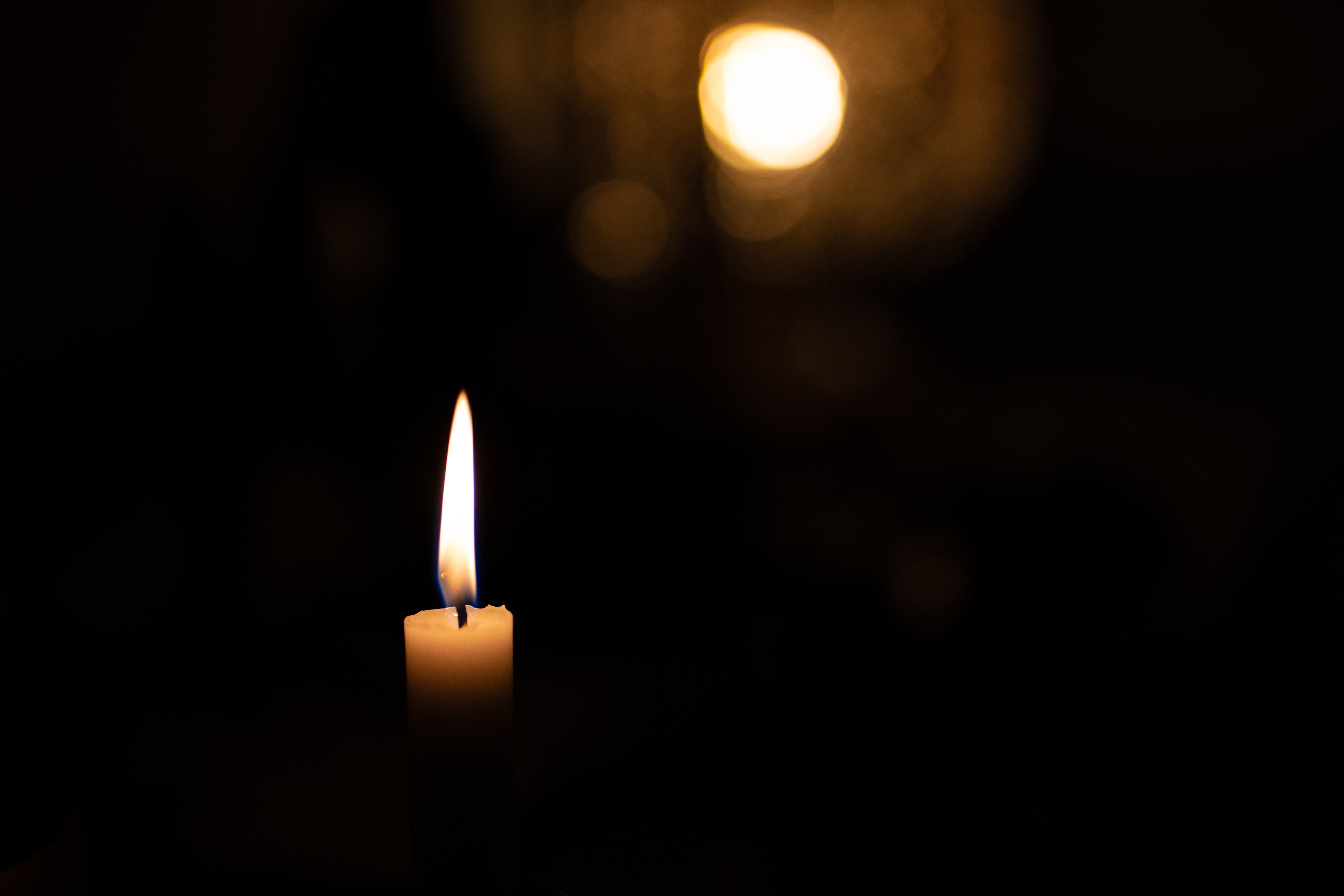 Image of a candle in a dark room.